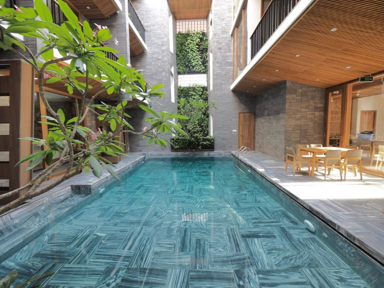 Hồ bơi nằm giữa các tòa nhà như 1 dòng sông xanh ngát chảy qua khu rừng nhiệt đới. (Nguồn: Facebook.com)